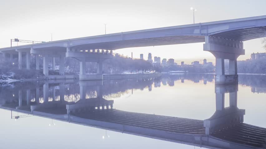 The Industrial Looking Dartmouth Bridge and Distant Downtown Minneapolis Reflect in a Calm Mississippi River during a Spring Twilight 4K UHD Timelapse