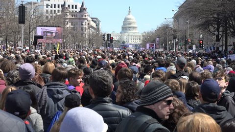 WASHINGTON, DC - MAR. 24, 2018: Audience cheers for student speaker We Will Vote on jumbotron, hundreds of thousands of students & others at the massive rally on Pennsylvania Ave. March for Our Lives
