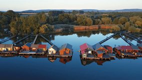 Aerial panorama of traditional fishing houses line on the lake shore, Hungary.