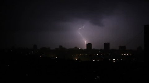 Lightning bolt in the middle of the night during a storm in the city