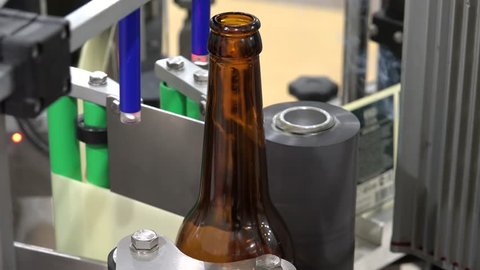 Automatic Beer Bottling Line. Applying the label with the laser drawing of release date. 