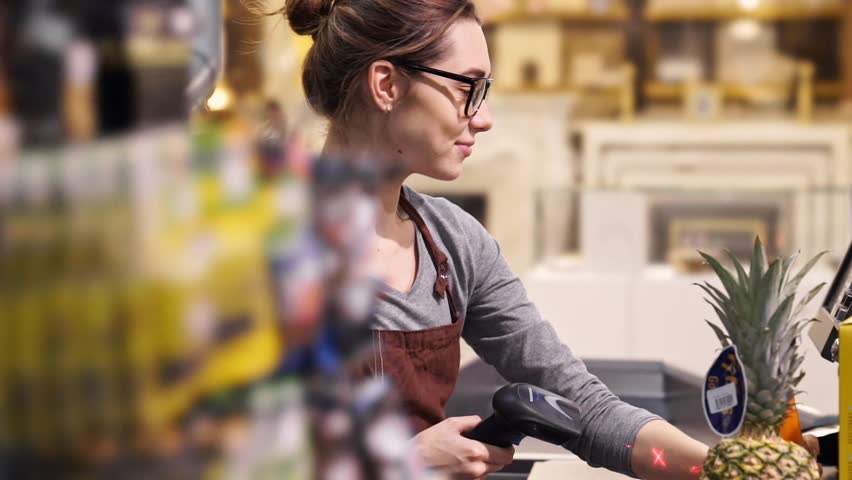 Happy female cashier scanning grocery items at supermarket Royalty-Free Stock Footage #1009049552