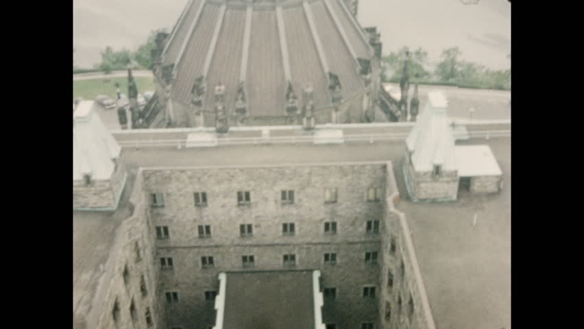 1950s: CANADA AND UNITED STATES: church spire. View across city. Building and clock tower. Monument in park