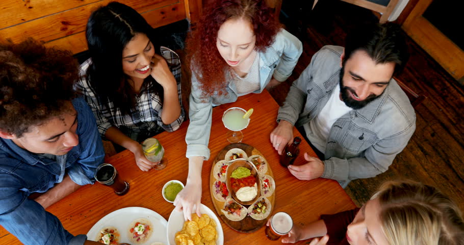 Happy friends having dinner and drinks in bar 4k