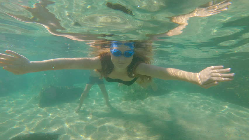 Slowmotion shot of a young woman snorkeling and having fun in a sea