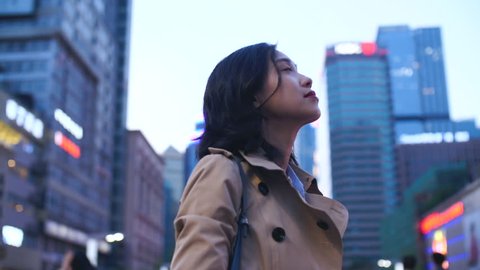 Slow Motion Of Beautiful Chinese Woman Looking Up to The Cityscape In The City  