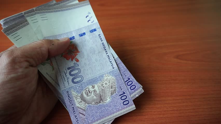 Malaysian currency (MYR): Hand is calculating Ringgit Malaysia currency notes. There is a hundred ringgit of malaysia that is stacked on the table. | Shutterstock HD Video #1009078607