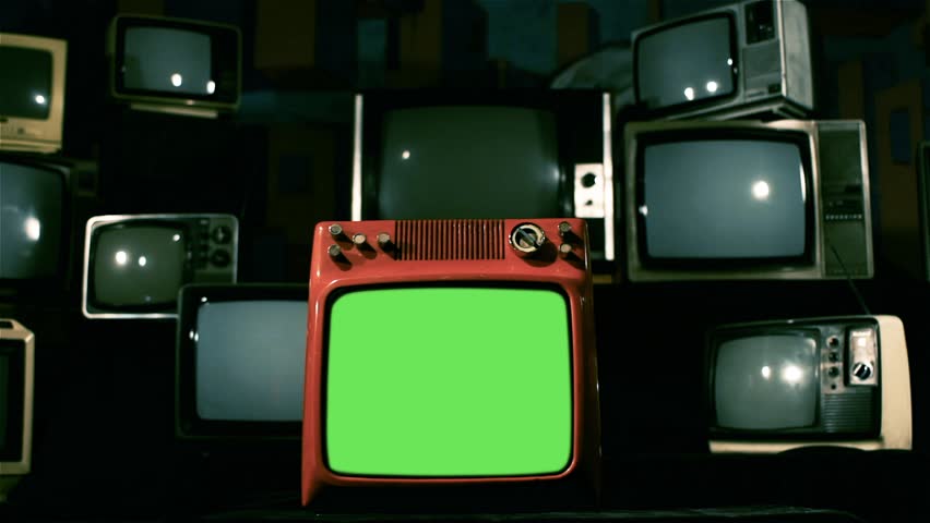 A Vintage Red Television with Green Screen over Many Retro TVs from the 80s and 90s. Dolly Shot. You can Replace Green Screen with the Footage or Picture you Want with “Keying” effect in AE. Royalty-Free Stock Footage #1009079108