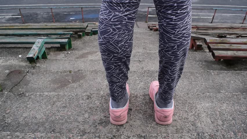 Young athletic girl goes down to the stadium
