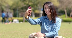 Woman taking selfie on mobile phone in city park