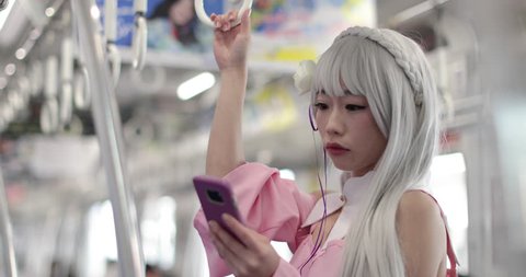 Japanese female in train looking at smart phone, Harajuku, Tokyo, Japan