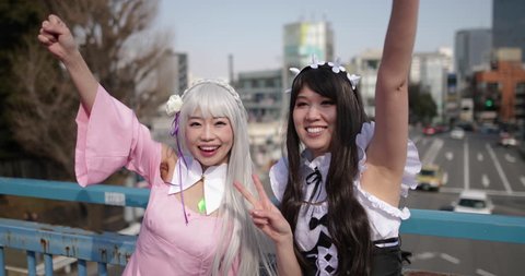 Portrait of two Japanese female friends looking to camera, Harajuku, Tokyo, Japan