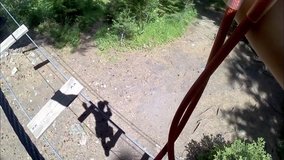 Personal perspective of climbing in adventure rope park, climbing trees in forest in summer - video HD