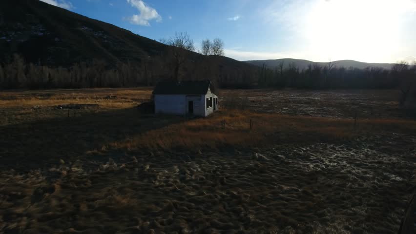 Aerial broken and forgotten buildings in a farmers field.