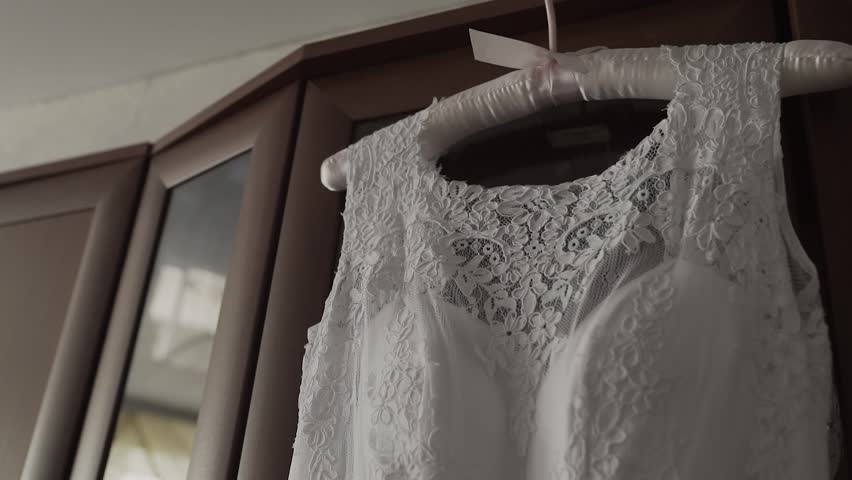 wedding dress hanging in front of the window