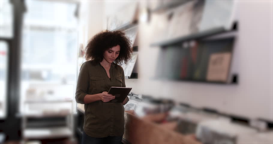 Portrait of small business owner using digital tablet in a record store