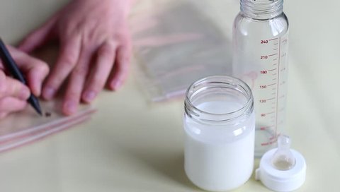 Labeling milk storage containers with the date and time. Breast milk freezer bags