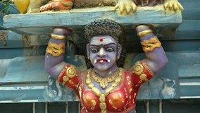 Elaborately detailed. colorfully painted sculpture of a Hindu goddess with purple skin and tusks. inside a popular temple in Sri Lanka. FullHD video 1080p
