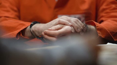 Inmate warms up wrists in handcuffs, gives evidence, detective writing testimony