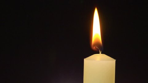 A single white candle burning. Looping for use as a background or illustration of remembrance or celebration. The eternal flame.