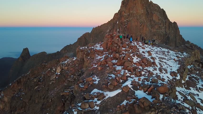 aerial view of unrecognizible climbers on summit of the Lenana peak of Mount Kenya during sunrise