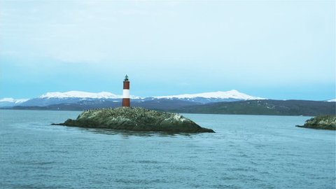 Lonely Lighthouse on a small Islet in the Beagle Channel, Ushuaia, Argentina, South America. The Andes Mountains in the Background.