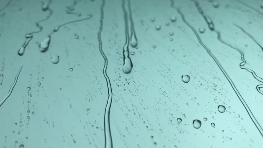 Raindrops of white water falling down on glass. Perfect for digital composing. Royalty-Free Stock Footage #1009147229