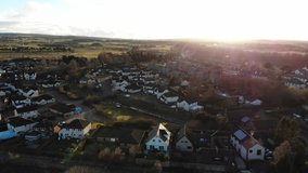 Aerial drone footage of suburban houses and fields in the evening Spring.
