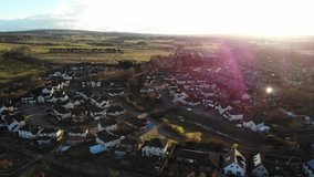 Aerial drone footage of suburban houses and fields in the evening Spring.