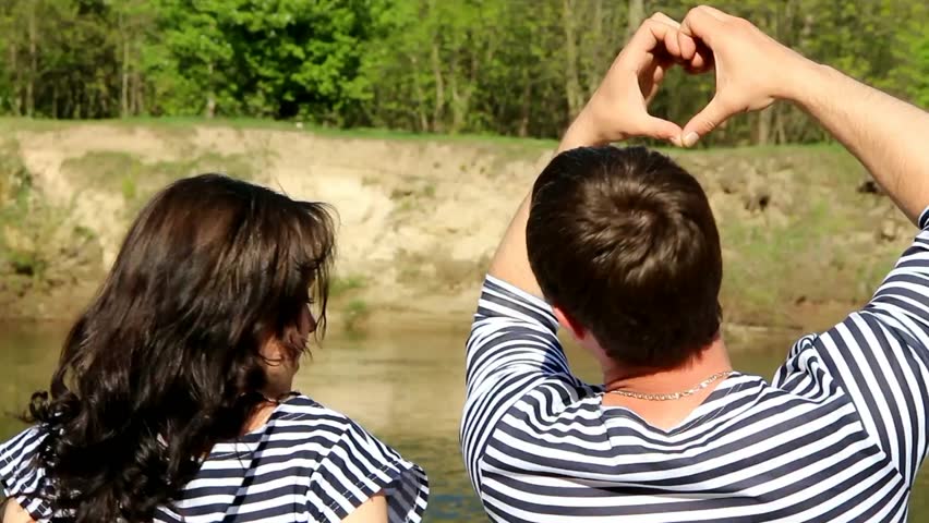Pregnant couple of man and woman making hearts from hands. Man, woman in love. Love concept. Hearts made from hands of people in love. Happy family. 