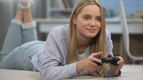 Teenage girl gamer playing shooter with joystick, very emotional, happy to win