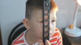child in an ophthalmic clinic. Checking visual acuity with a line of ski-like - Powered by Shutterstock - Get 15% off with code: PIKWIZARD15