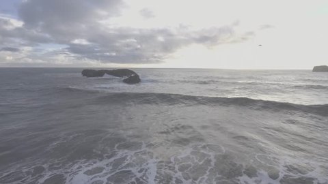 Watch as the waves flow in from Iceland's southern coast during the golden hour. - Βίντεο στοκ