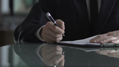 Businessman signing contract after successful negotiation, deal acceptance