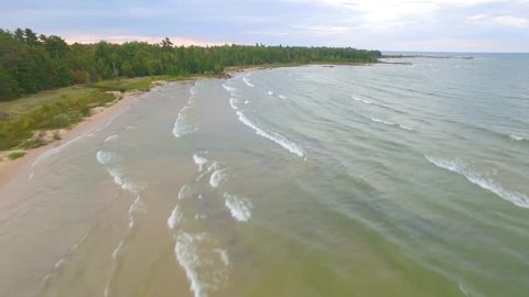Beautiful Lake Michigan shoreline jib/pan shot close to small waves. - Βίντεο στοκ