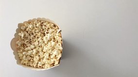 hand taking popcorn from a container