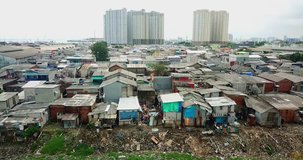 Aerial view of slum houses on lakeside with apartment background at Jakarta suburbs area, Indonesia. Shot in 4k resolution