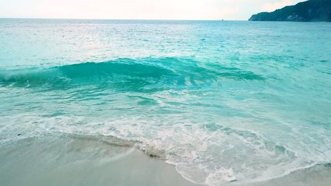 Drone footage of turquoise waves crashing on Kelingking Beach, in Nusa Penida Island, Bali Indonesia