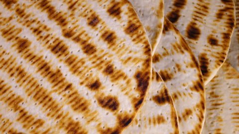 Traditional tasty flat bread (lavash, pita, chapati, scone) rotating in 4K. Closeup top view of food texture.