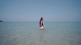 Beautiful young woman in swimsuit with snorkeling  mask having fun in the sea water, enjoying sunny summer day on her beach tropical holiday - video in slow motion
