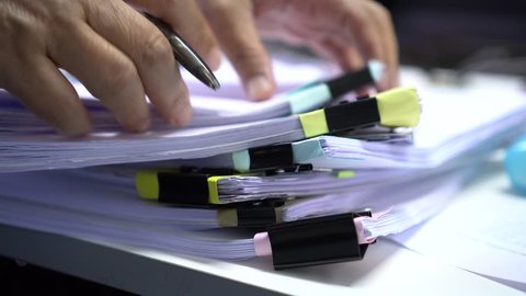 Businessman searching documents files or information in Stack of papers folder on work in office, Business report paper or piles of unfinished document achieves with clips on offices, Business concept