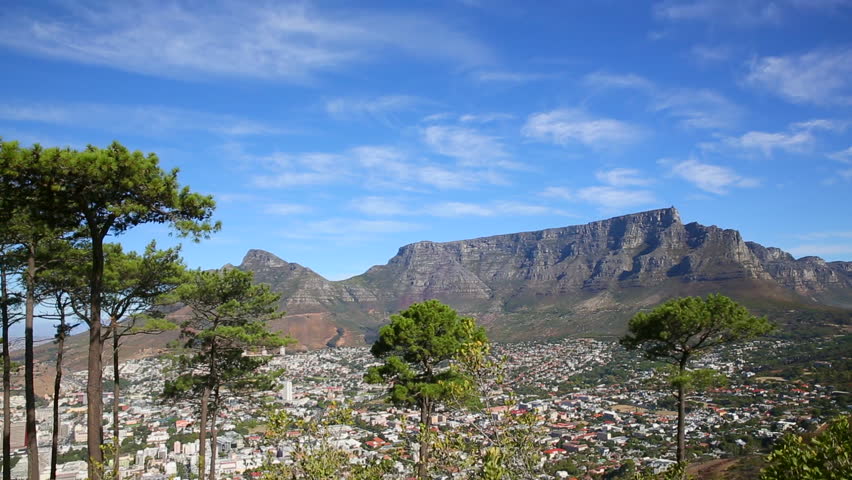 Landscape of Table Mountain and Lions Head with Cape Town city bowl with blue skies and puffy clouds.