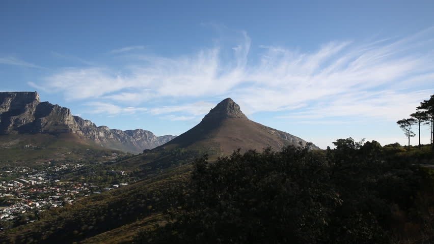 Landscape of Table Mountain and Lions Head with Cape Town city bowl with blue skies and puffy clouds.