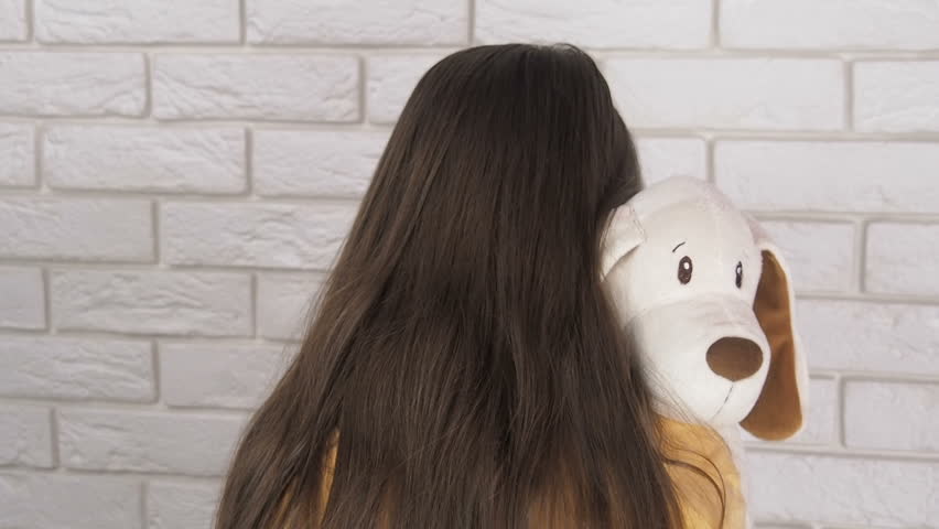 The child is depressed. A little girl is hugging a toy.