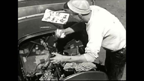 CIRCA 1950s - A schoolboy works on his hotrod while reading Hot Rod magazine and, after a test run at the racetrack, he checks his engine.