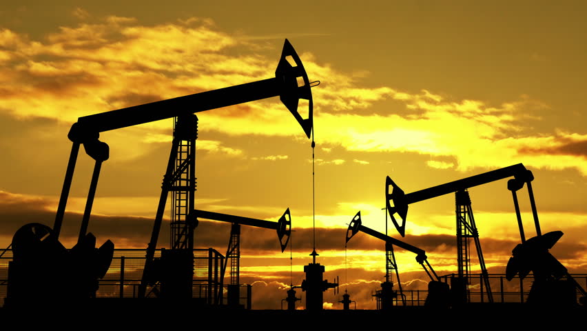 Oil pumpjacks against orange evening cloudscape