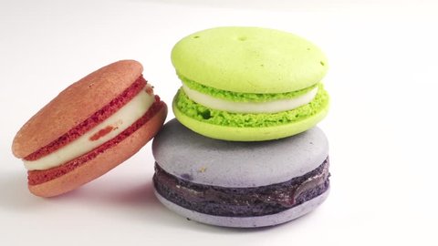 Three colorful French Macarons on the white background. Slide from right to left