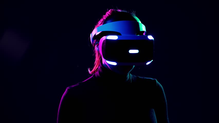 Young woman in VR headset looks around and wonders how amazing. Virtual reality helmet on black background Royalty-Free Stock Footage #1009215581