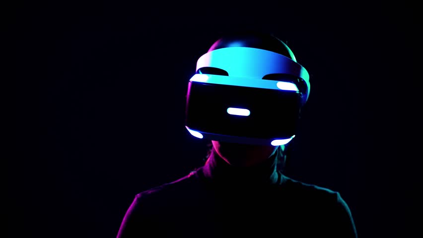 Young woman in VR headset looks around and wonders how amazing. Virtual reality helmet on black background Royalty-Free Stock Footage #1009215587