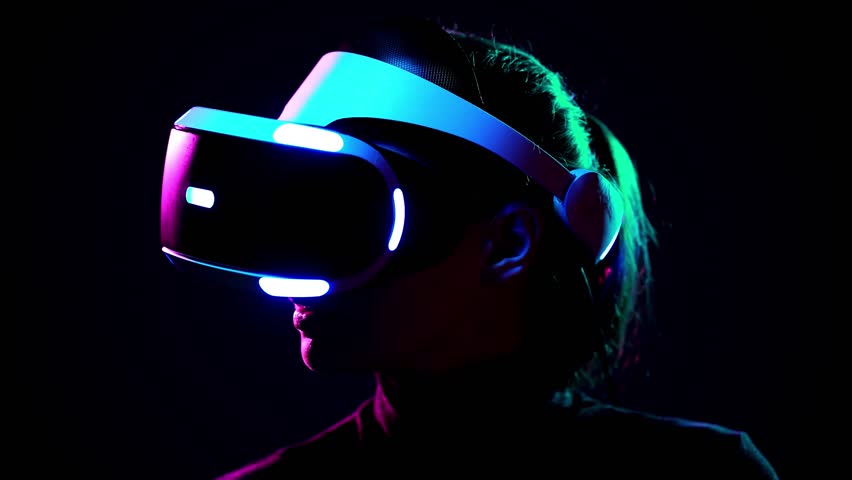 Young woman in VR headset looks around and wonders how amazing. Virtual reality helmet on black background Royalty-Free Stock Footage #1009215590